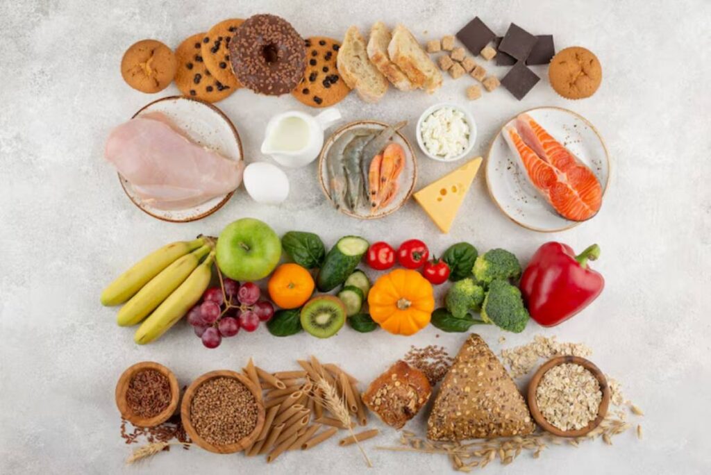 An assortment of healthy foods including fruits, vegetables, proteins, grains, and snacks beautifully arranged on a light background.