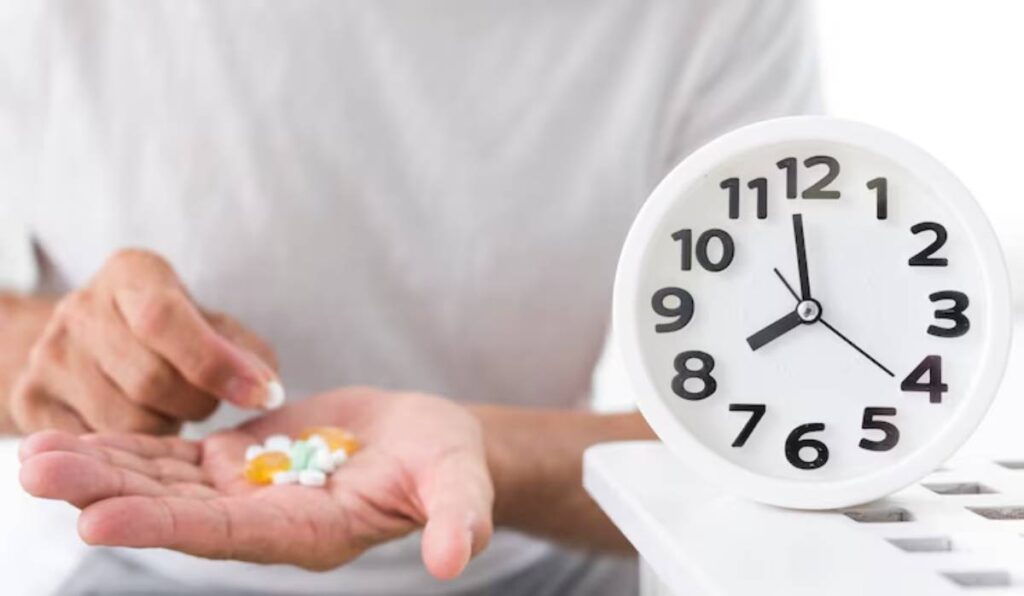 A person holds various pills in one hand while looking at a white clock displaying 10:10, emphasizing medication timing.