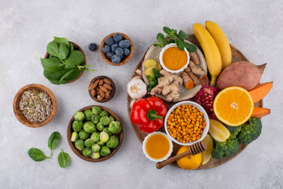 A variety of fresh fruits, vegetables, nuts, and spices arranged on a wooden platter, showcasing vibrant colors and healthy options.