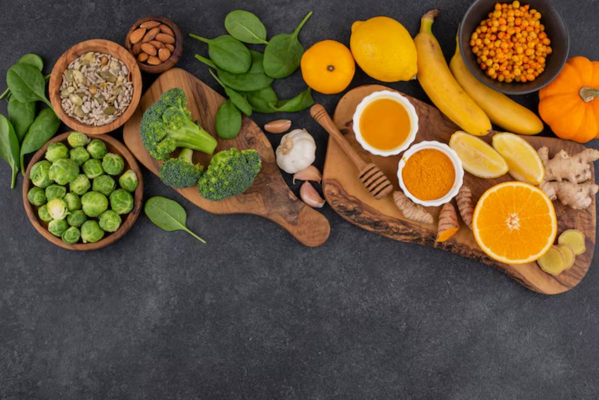 A vibrant array of fresh vegetables, fruits, nuts, and spices arranged on wooden boards, showcasing healthy ingredients for cooking.